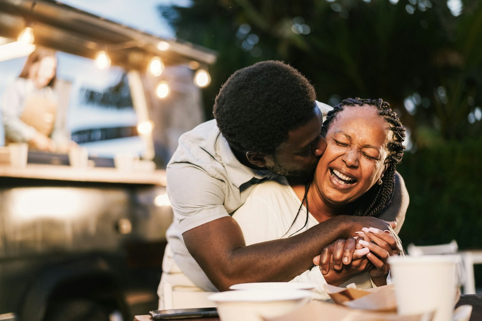 African mother and son having fun together outdoor at food truck restaurant
